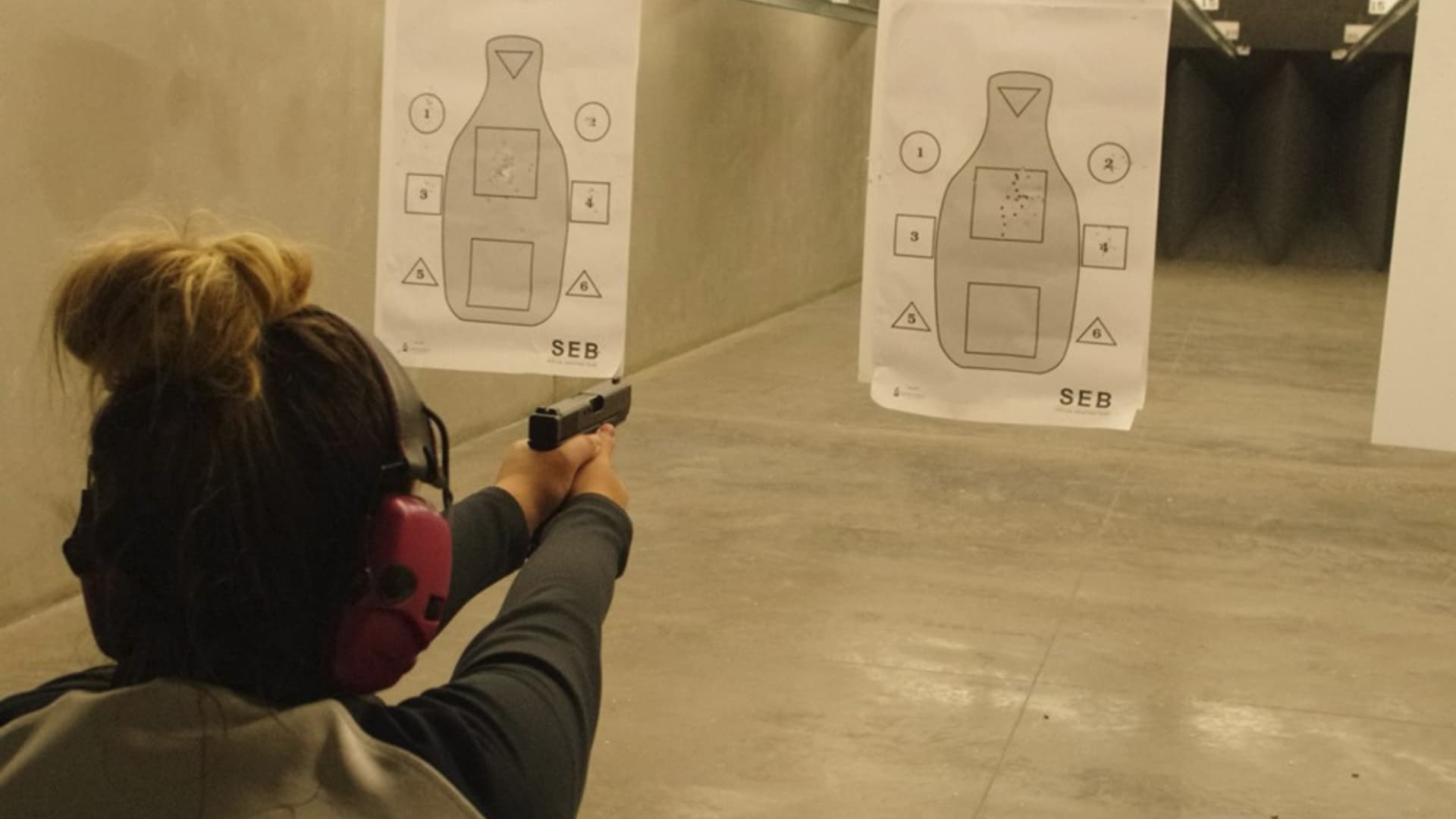 Woman shooting gun at shooting range